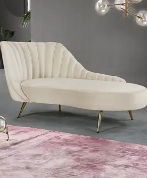 Custom cream velvet chaise lounge chair with brass legs in a modern luxury apartment living room at M3M Golfestate